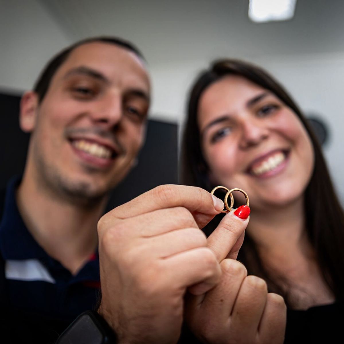 Casal a segurar as alianças