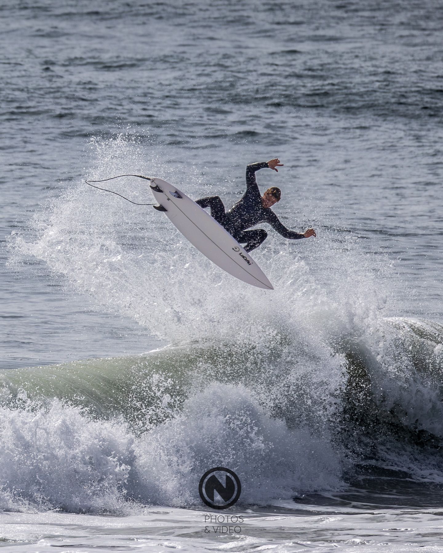 Surfista em manobra aérea sobre a onda