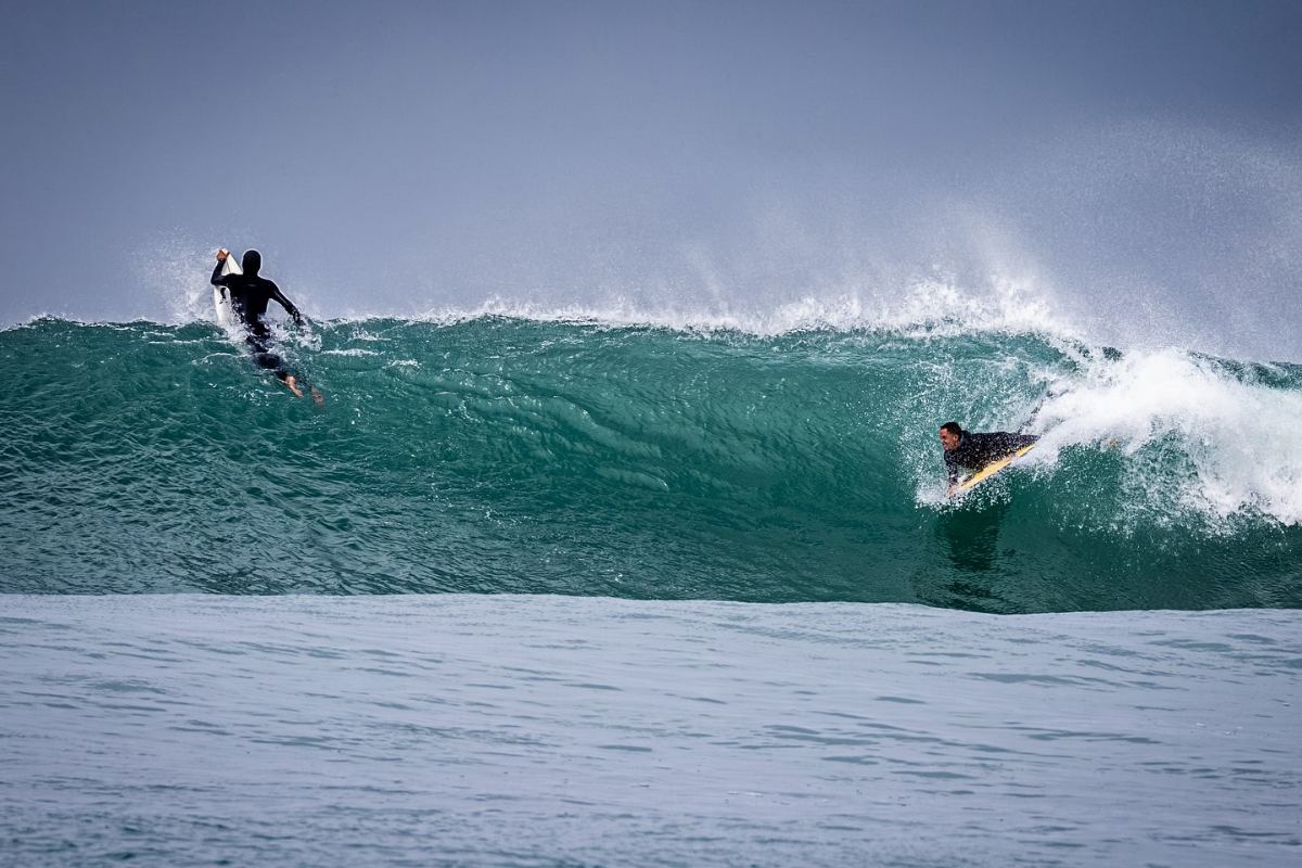 Surfista e bodyboarder a partilhar a mesma onda
